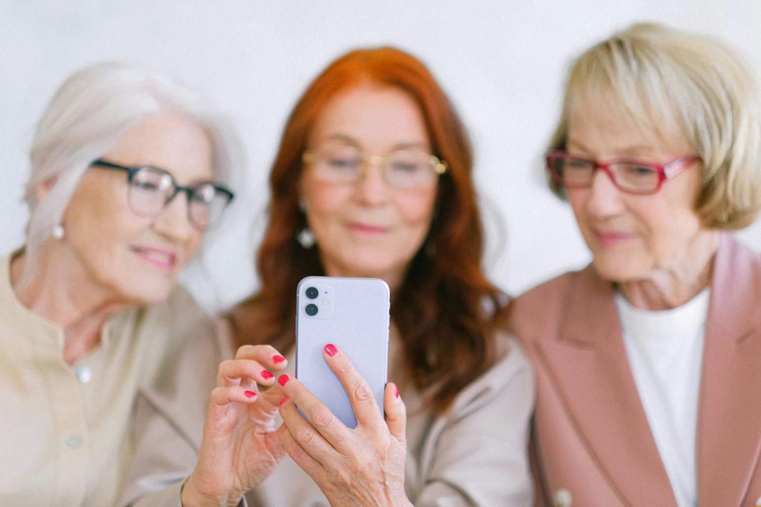 3 mature women reading tips online about sleeping better with menopause